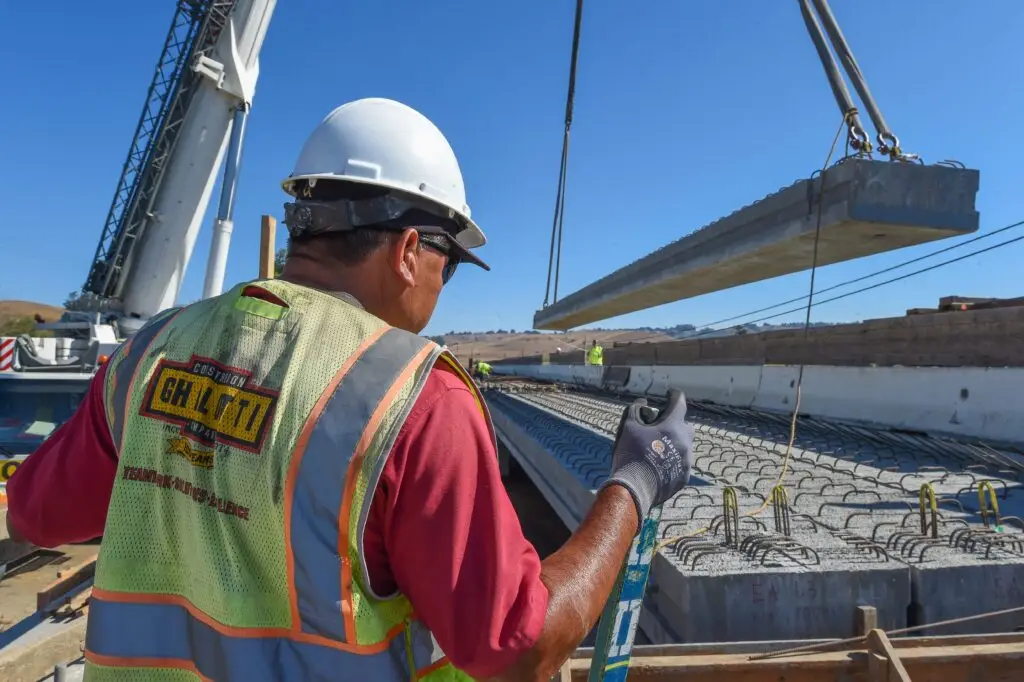 A Ghilotti crew worker oversees a girder being dropped into place in Valley Ford, CA